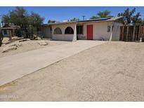 Charming single-story home featuring desert landscaping and a long driveway with a pop of color from a red front door at 4110 E Wagoner Rd, Phoenix, AZ 85032