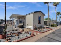 Inviting manufactured home featuring desert landscaping, covered parking, and a charming, well-maintained exterior at 8421 E Main St # 116, Mesa, AZ 85207