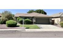 Charming single-story home featuring a well-manicured lawn, desert landscaping, and a spacious two-car garage at 9212 W Salter Dr, Peoria, AZ 85382