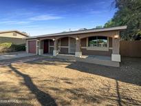 Inviting single-story home featuring a covered front porch and a spacious front yard at 1048 E 6Th Ave, Mesa, AZ 85204