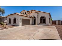 Charming single-story home features a well-manicured lawn, arched entryway, and a two-car garage at 15811 N 155Th Dr, Surprise, AZ 85374