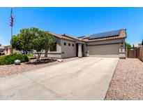 Charming single-story home featuring a two-car garage, desert landscaping and solar panels at 17562 W Gelding Dr, Surprise, AZ 85388