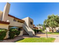 Condo exterior featuring well-manicured lawn, desert landscaping, and covered patio at 2020 W Union Hills Dr # 156, Phoenix, AZ 85027
