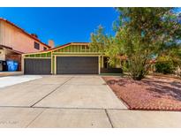 Inviting curb appeal with a green home exterior, flowering tree, three car garage and well-manicured landscaping at 2109 E Gelding Dr, Phoenix, AZ 85022