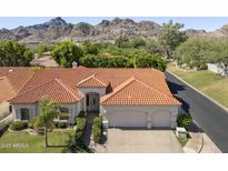 Stunning exterior view of a home featuring a red tile roof and mature landscaping with mountain views in the background at 3146 E Maryland Ave, Phoenix, AZ 85016