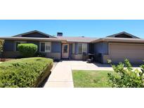 Charming home featuring manicured landscaping, a cozy front porch, and an attached garage at 5539 E Dragoon Ave, Mesa, AZ 85206