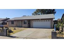 Charming single-story home features a two-car garage and a well-maintained front yard and driveway at 5916 W Pierce St, Phoenix, AZ 85043