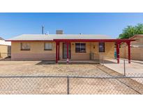 Cozy single-story home featuring a covered porch and a low, chain-link fence around the front yard at 6521 W Flower St, Phoenix, AZ 85033