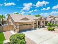 Charming home featuring a three-car garage, desert landscaping, and a refreshing private pool at 6967 W Irma Ln, Glendale, AZ 85308