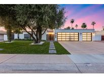 Charming single-story home with a modern design, lush lawn and three car garage at 8618 E Via De Encanto --, Scottsdale, AZ 85258