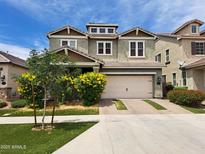 Two-story home featuring a two-car garage, beautiful landscaping, and a well-manicured lawn on a sunny day at 10036 E Naranja Ave, Mesa, AZ 85209