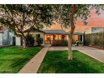 Charming single-story home with lush green lawn, mature trees, and welcoming front entrance at 1522 W Willetta St, Phoenix, AZ 85007