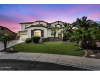 Elegant two-story home with a lush green lawn, palm trees, and a charming facade at 1755 E Tonto Dr, Chandler, AZ 85249