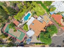 Stunning aerial view of the estate, showcasing a pool, tennis court, lush landscaping, and privacy at 5540 E Mercer Ln, Scottsdale, AZ 85254