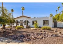 Charming home features a rock garden and lovely desert landscaping at 7036 E Sheena Dr, Scottsdale, AZ 85254