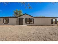 Charming single-story home with a desert landscape, neutral siding, and dark window shutters at 9735 W Altadena Dr, Casa Grande, AZ 85194