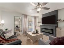 Inviting living room featuring a fireplace, sleek TV, tile flooring, and sliding glass doors to the outdoors at 9825 N 44Th Ave, Glendale, AZ 85302