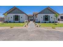 Charming single Gathering home with landscaped yard and welcoming walkway to the front door at 2095 N 77Th Pl, Mesa, AZ 85207