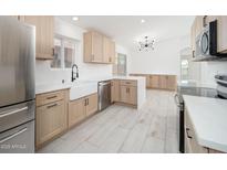 Bright kitchen featuring stainless steel appliances, wood cabinets, and a farmhouse sink at 21632 N 48Th St, Phoenix, AZ 85054