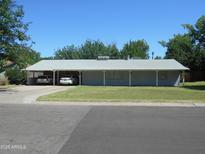 Charming single-story home with a long covered front porch and carport, nestled on a well-maintained lawn at 2818 E Elm St, Phoenix, AZ 85016