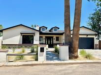 Charming home with an inviting front yard, black trimmed windows and a driveway leading to an attached garage at 3021 N 47Th St, Phoenix, AZ 85018