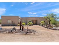 Charming stucco home featuring desert landscaping, mature trees, and circular driveway at 31825 N 141St St, Scottsdale, AZ 85262