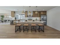 Open concept kitchen with light wood cabinets, stone countertops, and modern pendant lighting at 5028 W Shangri La Rd, Glendale, AZ 85304