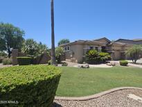 Attractive single-Gathering home featuring lush landscaping, well-manicured lawn, and mature trees for optimal curb appeal at 549 E Benrich Dr, Gilbert, AZ 85295