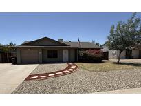 Charming single-story home boasts low-maintenance desert landscaping and a quaint stone walkway leading to the front door at 10910 N 72Nd Dr, Peoria, AZ 85345