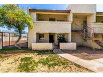 Inviting two-story condo with neutral stucco exterior, fenced yard, and landscaped walkway at 11026 N 28Th Dr # 81, Phoenix, AZ 85029