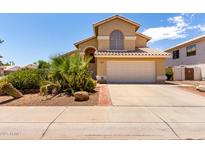 Charming home featuring a two-car garage, desert landscaping, and a tile roof in a sunny neighborhood at 1403 W Goldfinch Way, Chandler, AZ 85286