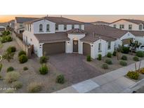 Beautiful two-story home with a well-manicured front yard, brick driveway, and two-car garage at 14274 W Sand Hills Rd, Surprise, AZ 85387