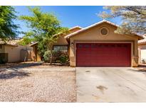 Charming home with low maintenance landscaping, flowering bushes, and a two car garage at 16118 W Morning Glory St, Goodyear, AZ 85338
