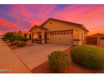 Charming single-story home featuring a two-car garage, landscaped yard, and inviting covered porch at 22403 W Harrison St, Buckeye, AZ 85326