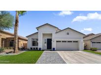 Charming single-story home featuring a well-manicured lawn, modern architectural details, and a welcoming entrance at 389 W Fairway Pl, Chandler, AZ 85225