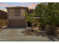 Two-story home boasts a two-car garage and desert landscaping, providing an inviting curb appeal at 43813 W Rio Lobo Dr, Maricopa, AZ 85138