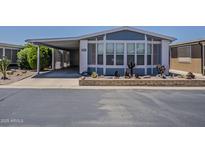Charming blue home with a covered carport and desert landscaping adds appeal at 5735 E Mcdowell Rd # 108, Mesa, AZ 85215