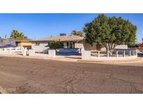 Charming single-story home featuring a low-walled front yard, mature shade tree, and inviting curb appeal at 5827 N 22Nd Dr, Phoenix, AZ 85015