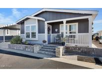 Charming home with well-maintained landscaping, front porch seating, and easy access with wide concrete steps at 650 N Hawes Rd # 2819, Mesa, AZ 85207