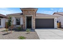 Stylish single-Gathering home featuring stone accents and a gray garage door for a modern, appealing facade at 7421 S 76Th Ln, Laveen, AZ 85339
