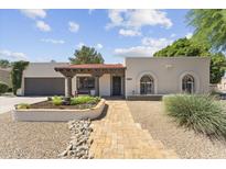 Charming home with a tile roof and well-manicured front yard, offering inviting curb appeal at 7835 E Cannon Dr, Scottsdale, AZ 85258