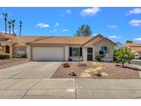 Charming single-story home showcasing a well-maintained front yard and a two-car garage at 823 W Kyle Ct, Gilbert, AZ 85233