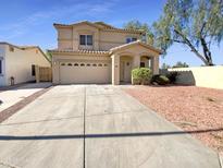 Inviting two-story home showcasing desert landscaping, a two-car garage, and a welcoming front entrance at 13106 W Calavar Rd, Surprise, AZ 85379