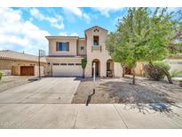 Charming two-story home featuring a spacious driveway and a well-manicured front yard with a mature tree at 16917 W Sonora St, Goodyear, AZ 85338