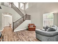 Cozy living room featuring a staircase, wood-look floors, neutral paint, and comfortable furnishings at 16917 W Sonora St, Goodyear, AZ 85338