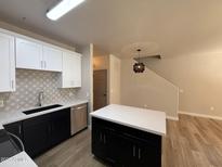 Modern kitchen featuring sleek black and white cabinetry, an island, and stainless steel appliances at 1718 W Colter St # 142, Phoenix, AZ 85015