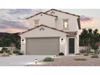 Two-story stucco home with a two-car garage and well-maintained desert landscaping at dusk at 17395 W Jessie Ln, Surprise, AZ 85387