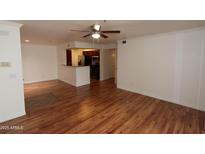 Spacious living room features hardwood floors, a ceiling fan, and open concept kitchen at 2025 E Campbell Ave # 120, Phoenix, AZ 85016
