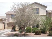 Lovely home featuring a two-car garage, lush landscaping, and a well-maintained lawn at 21050 E Munoz St, Queen Creek, AZ 85142