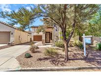 Charming home with a well-maintained front yard, desert landscaping, and covered entryway at 21050 E Munoz St, Queen Creek, AZ 85142